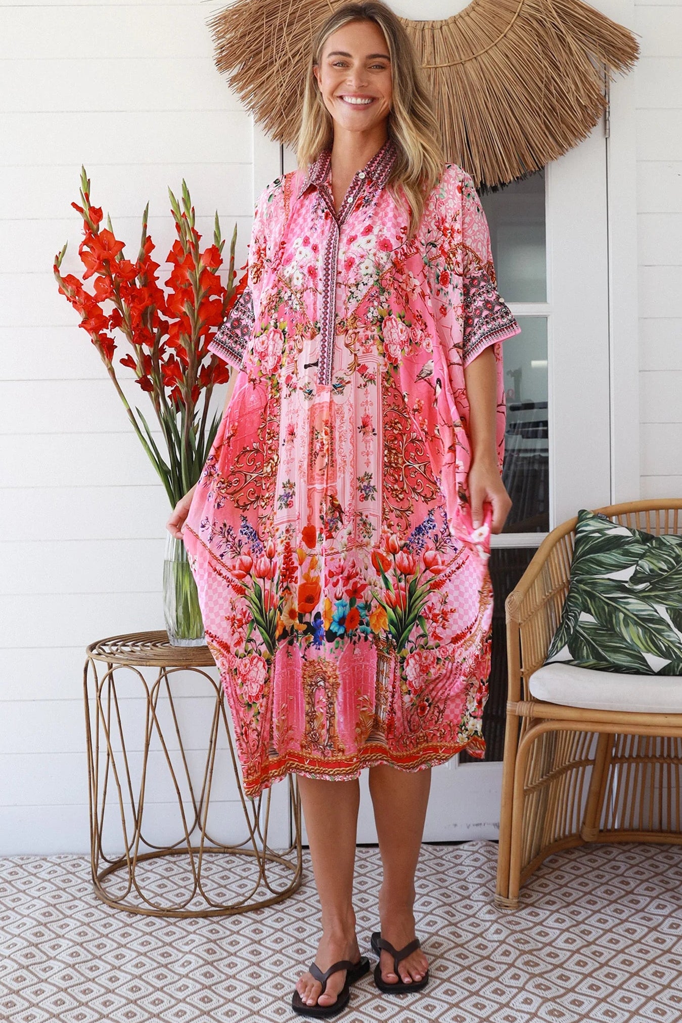 “Woman in pink floral viscose crepe kaftan midi dress with rhinestone buttons by Peacock Feathers – bohemian resort wear Australia”