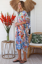 Woman in white viscose crepe kaftan midi dress with coral, jade and cobalt florals by Peacock Feathers Resort Luxe – Boho Dresses Australia