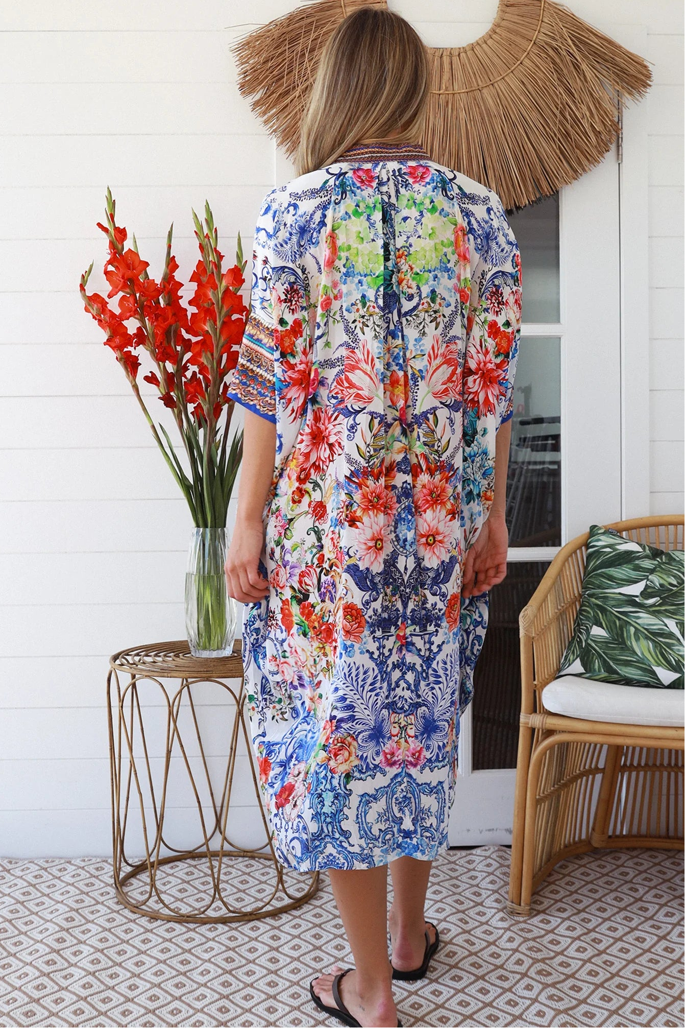 Woman in white viscose crepe kaftan midi dress with coral, jade and cobalt florals by Peacock Feathers Resort Luxe – Boho Dresses Australia
