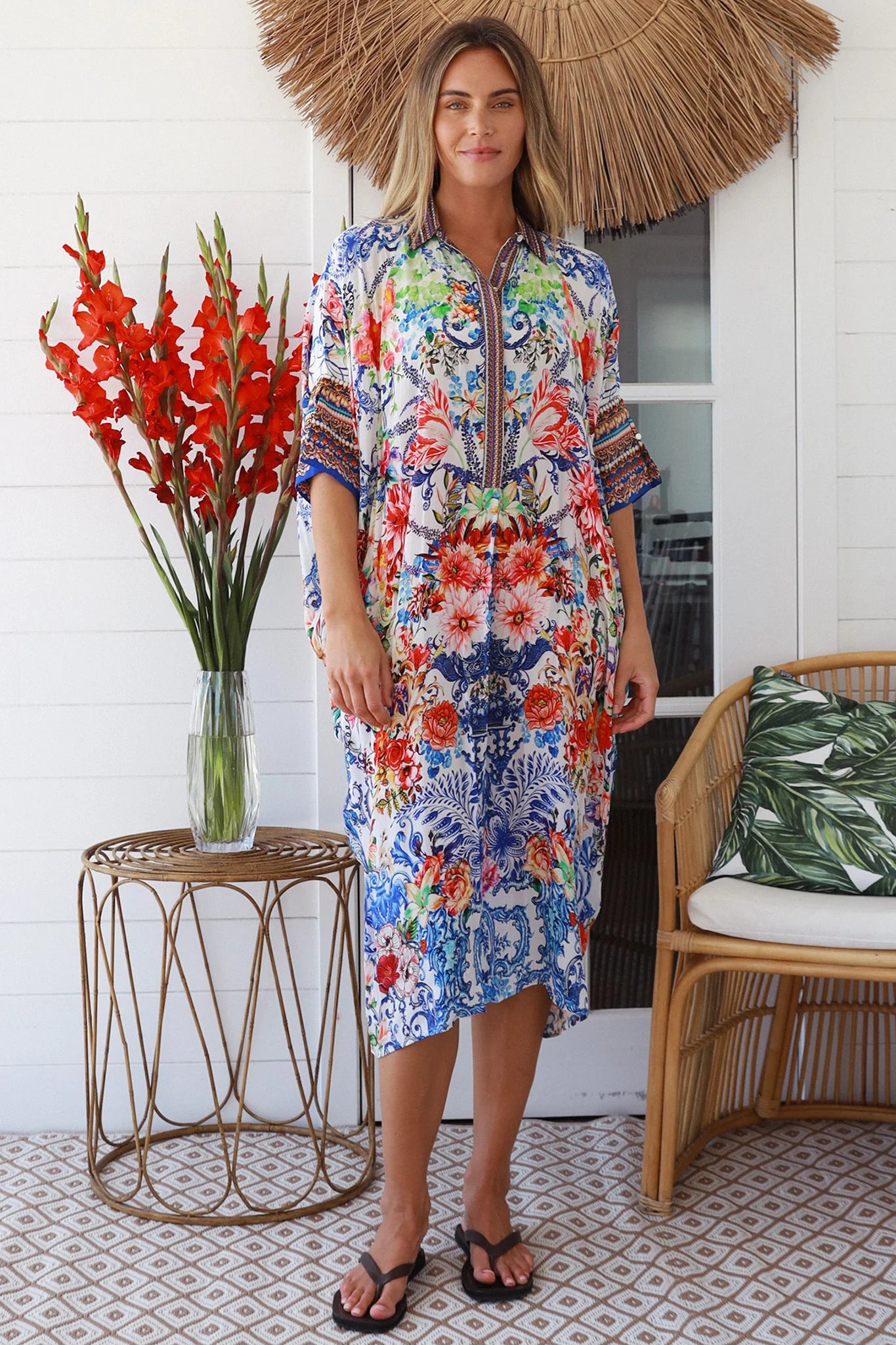 Woman in white viscose crepe kaftan midi dress with coral, jade and cobalt florals by Peacock Feathers Resort Luxe – Boho Dresses Australia