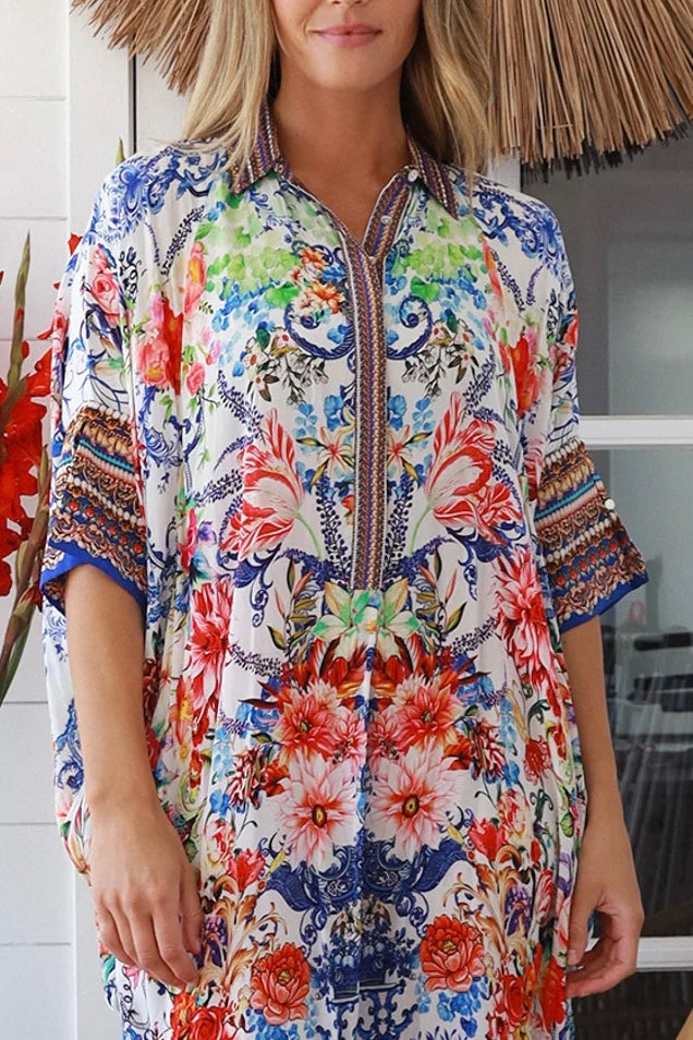 Woman in white viscose crepe kaftan midi dress with coral, jade and cobalt florals by Peacock Feathers Resort Luxe – Boho Dresses Australia