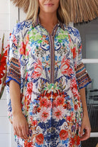 Woman in white viscose crepe kaftan midi dress with coral, jade and cobalt florals by Peacock Feathers Resort Luxe – Boho Dresses Australia