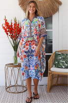 Woman in white viscose crepe kaftan midi dress with coral, jade and cobalt florals by Peacock Feathers Resort Luxe – Boho Dresses Australia