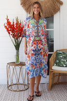 Woman in white viscose crepe kaftan midi dress with coral, jade and cobalt florals by Peacock Feathers Resort Luxe – Boho Dresses Australia