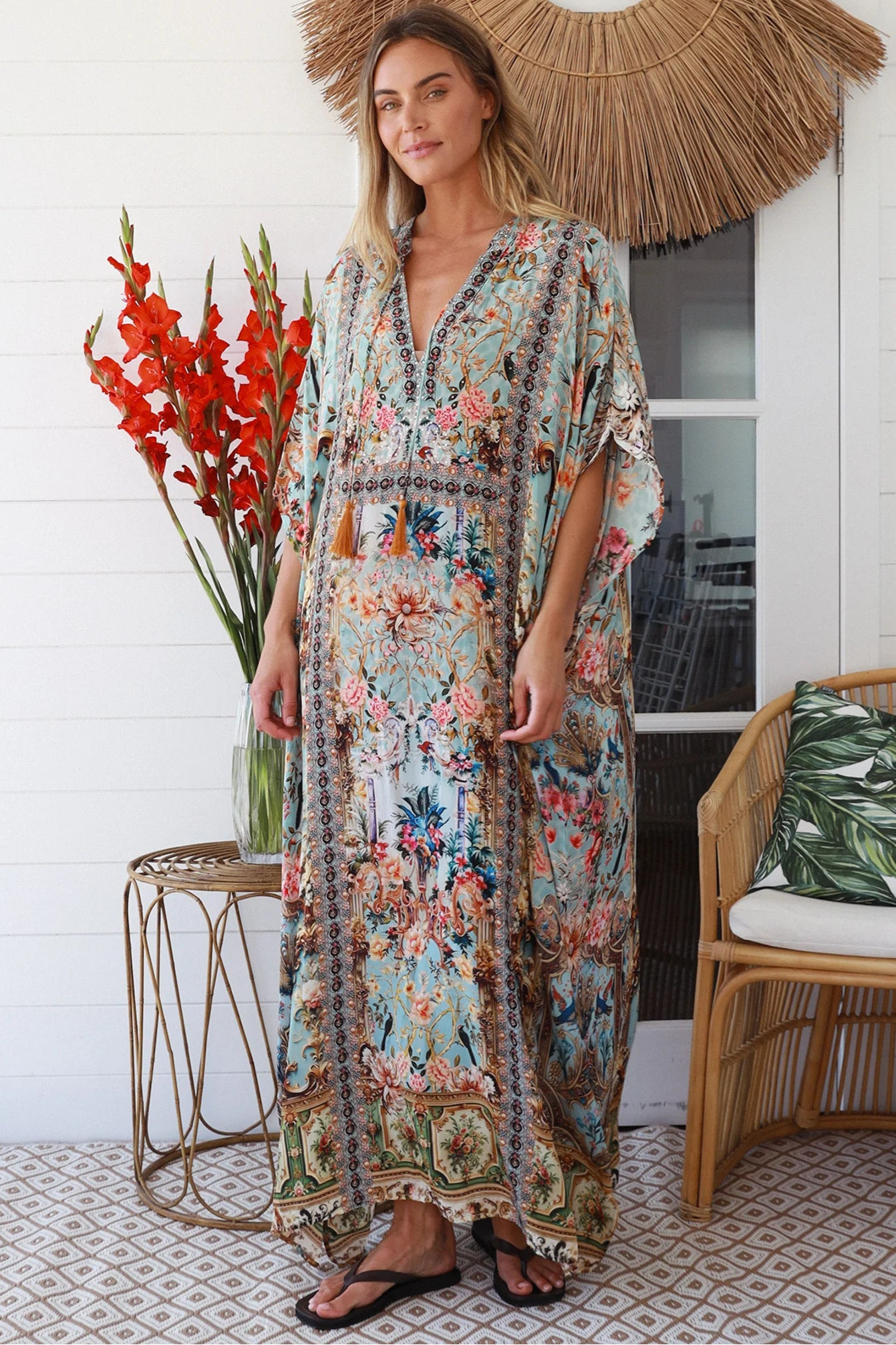 Woman wearing turquoise floral resort luxe kaftan with tassel ties - boho resortwear Australia