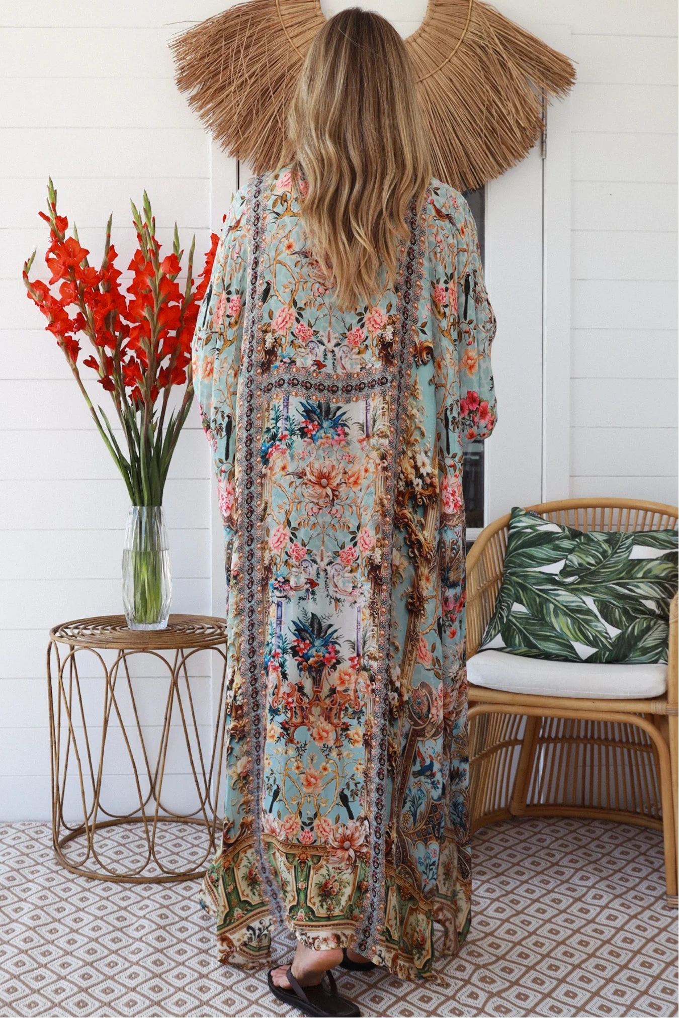 Woman wearing turquoise floral resort luxe kaftan with tassel ties - boho resortwear Australia