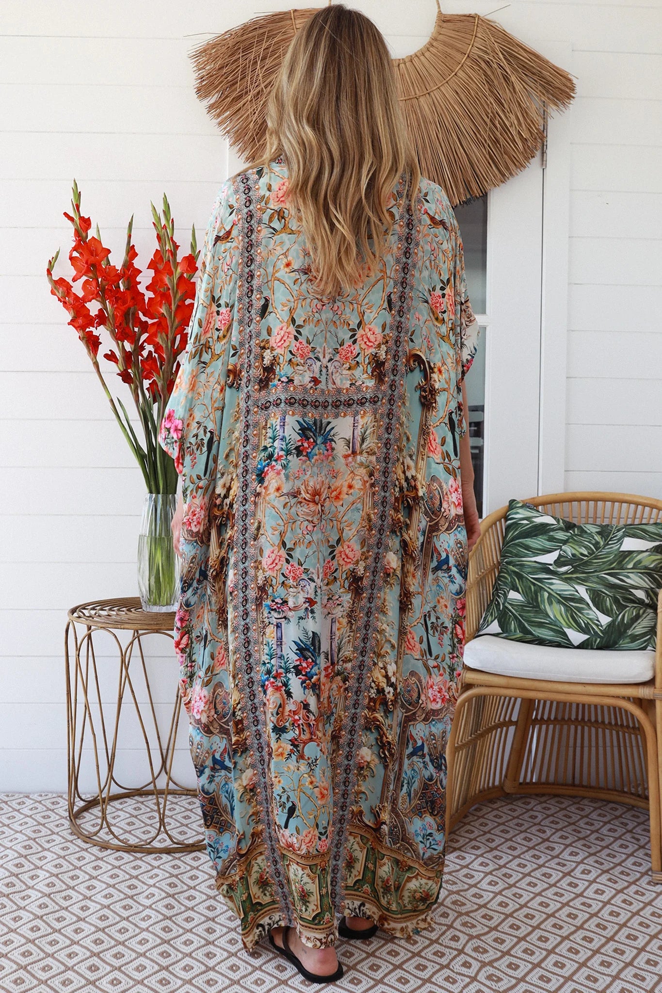 Woman wearing turquoise floral resort luxe kaftan with tassel ties - boho resortwear Australia
