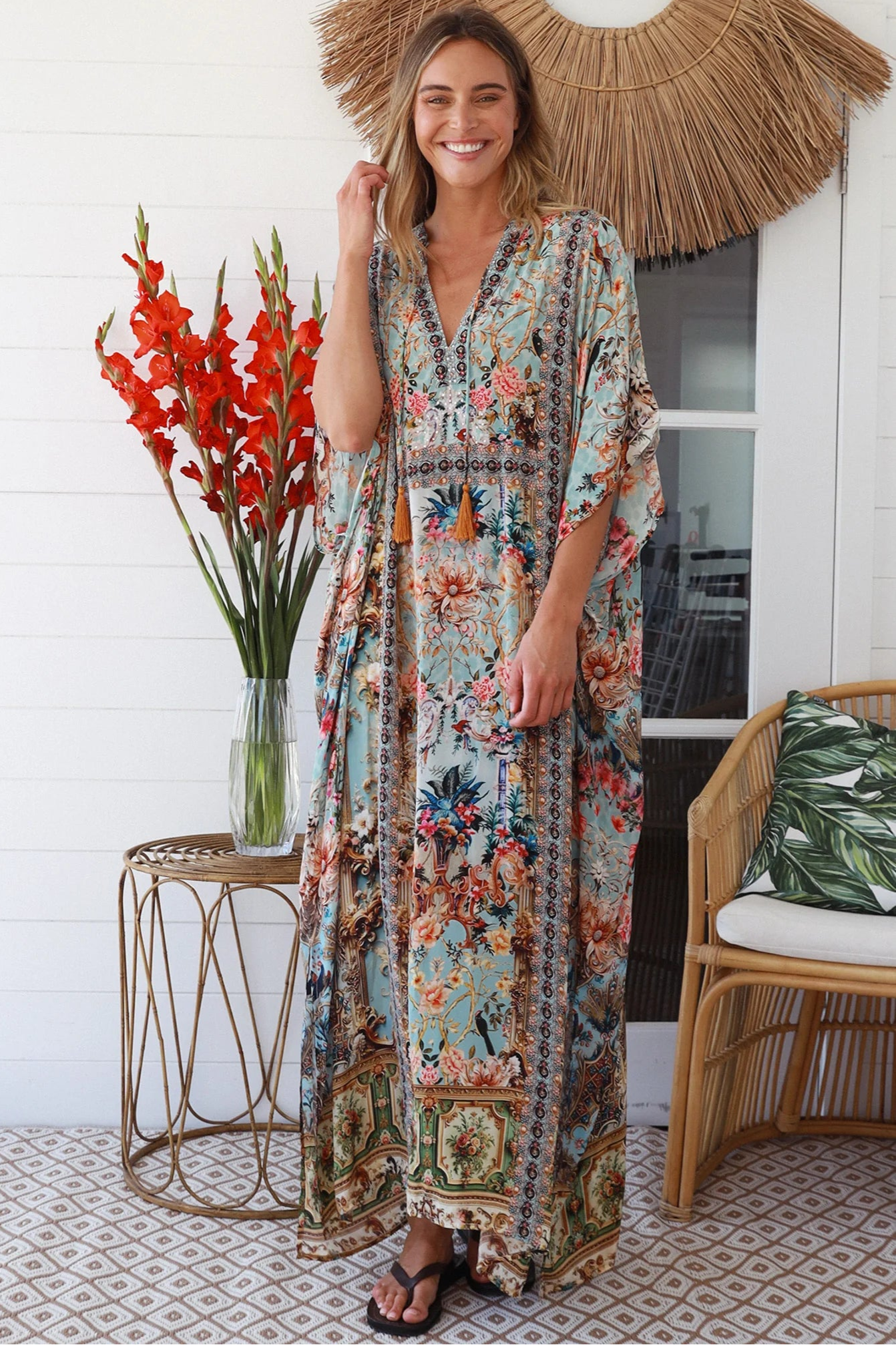 Woman wearing turquoise floral resort luxe kaftan with tassel ties - boho resortwear Australia
