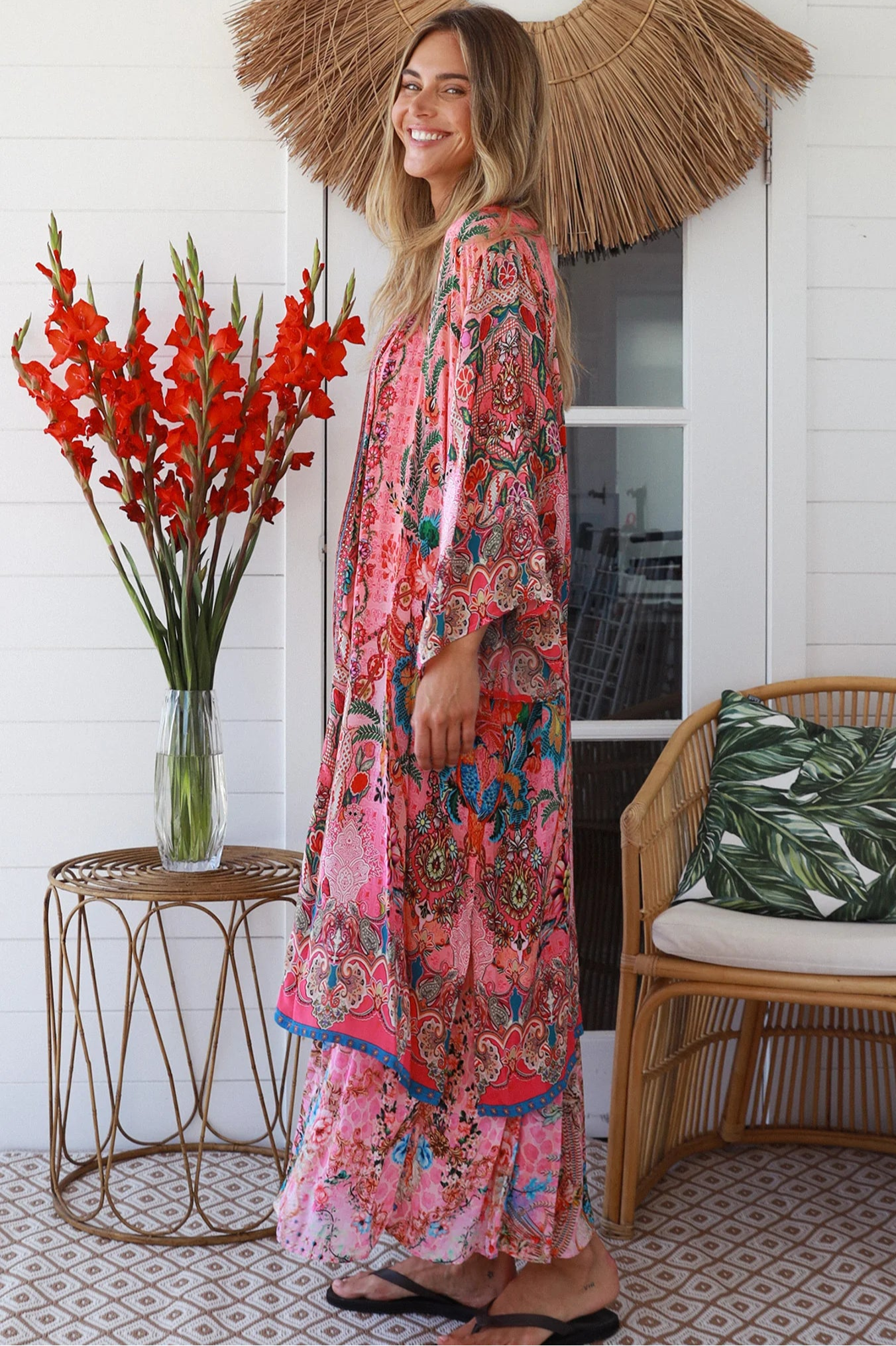 Woman in rose floral viscose-crepe kimono with turquoise accents and side splits - Peacock Feather Resort Luxe
