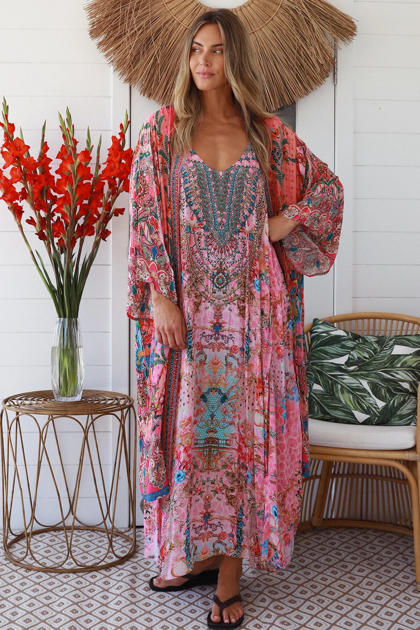 Woman in rose floral linen-viscose kimono with turquoise accents and side splits - Peacock Feather Resort Luxe