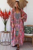 Woman in rose floral linen-viscose kimono with turquoise accents and side splits - Peacock Feather Resort Luxe