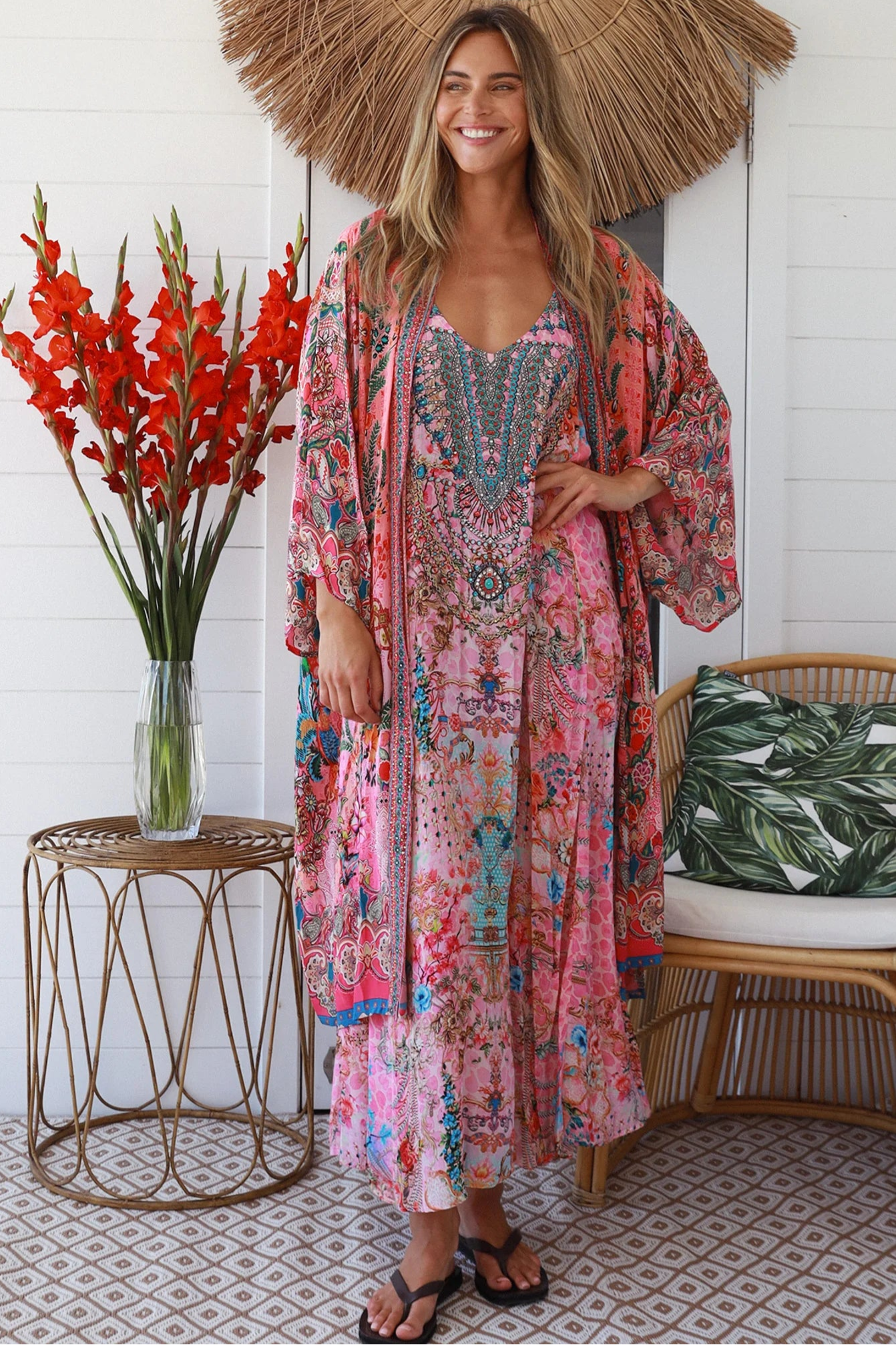 Woman in rose floral linen-viscose kimono with turquoise accents and side splits - Peacock Feather Resort Luxe