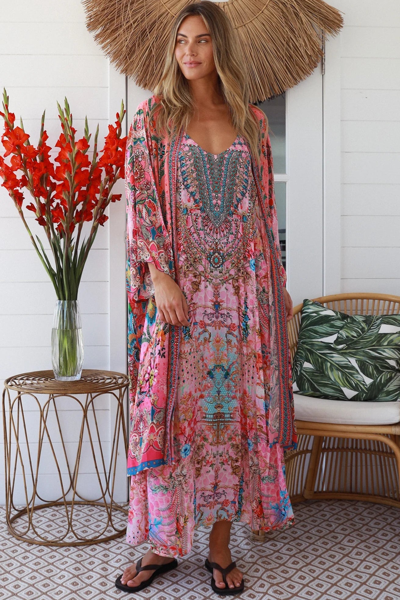 Woman in rose floral linen-viscose kimono with turquoise accents and side splits - Peacock Feather Resort Luxe