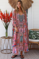 Woman in rose floral linen-viscose kimono with turquoise accents and side splits - Peacock Feather Resort Luxe
