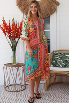 Woman in a colourful viscose-linen boho patchwork midi dress with v-neck collar, button front & 3/4 sleeves.