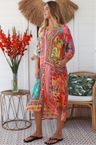Woman in a colourful viscose-linen boho patchwork midi dress with v-neck collar, button front & 3/4 sleeves.