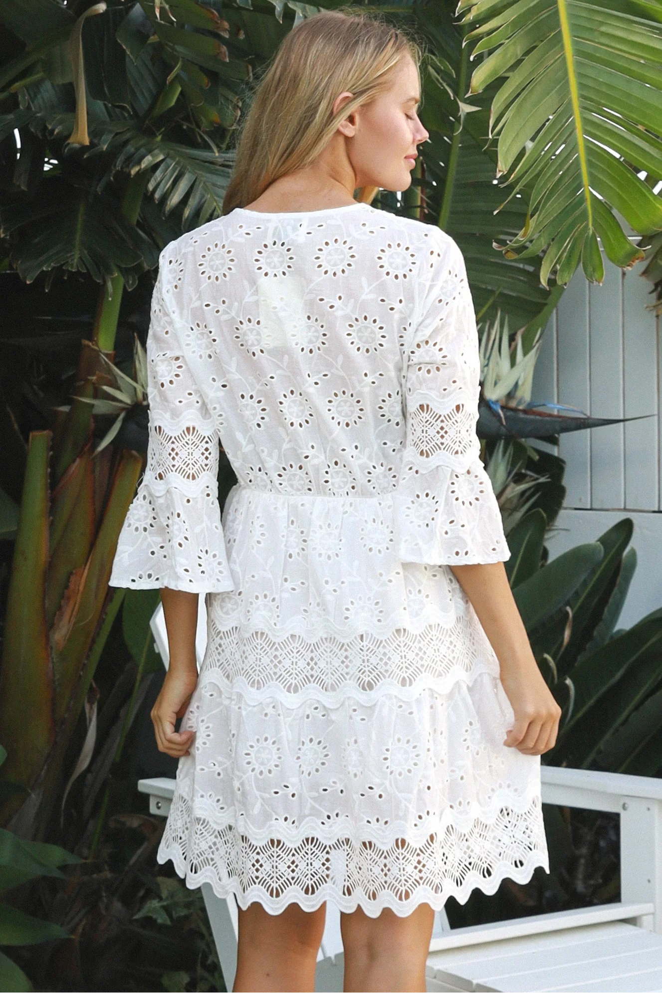 Woman in white embroidered anglaise cotton mini dress with crochet trims and scalloped tiers – Australian boho fashion