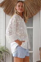 “Woman in white embroidered cotton button-down shirt with floral detailing – boho shirts Australia”