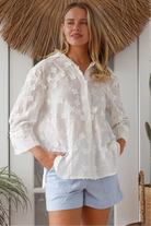 “Woman in white embroidered cotton button-down shirt with floral detailing – boho shirts Australia”