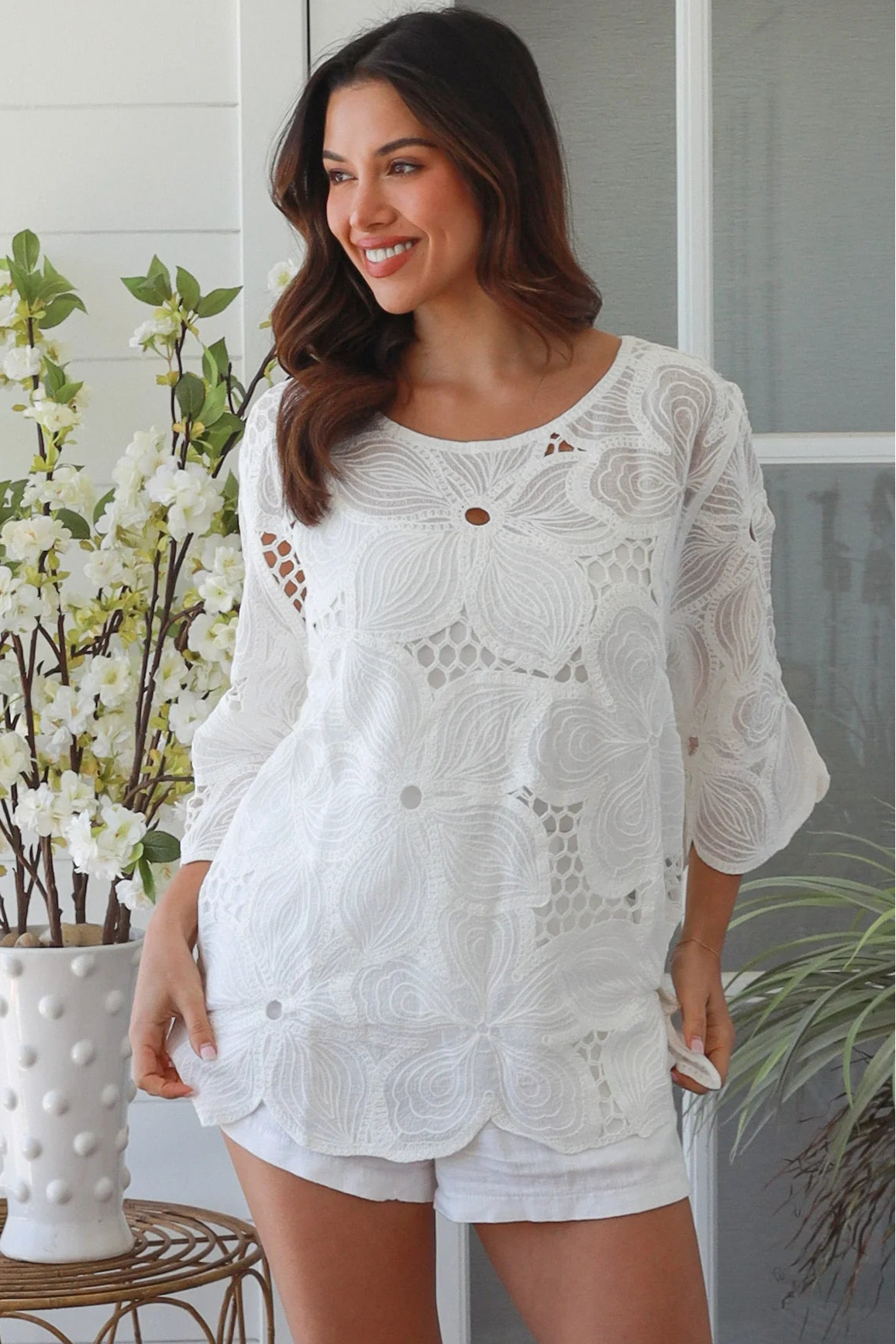 White embroidered cotton top with scalloped hem and three quarter sleeves styled for summer