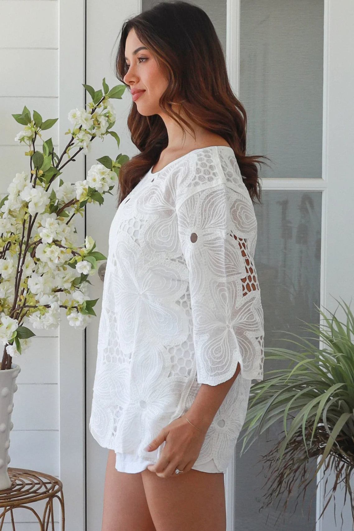 White embroidered cotton top with scalloped hem and three quarter sleeves styled for summer
