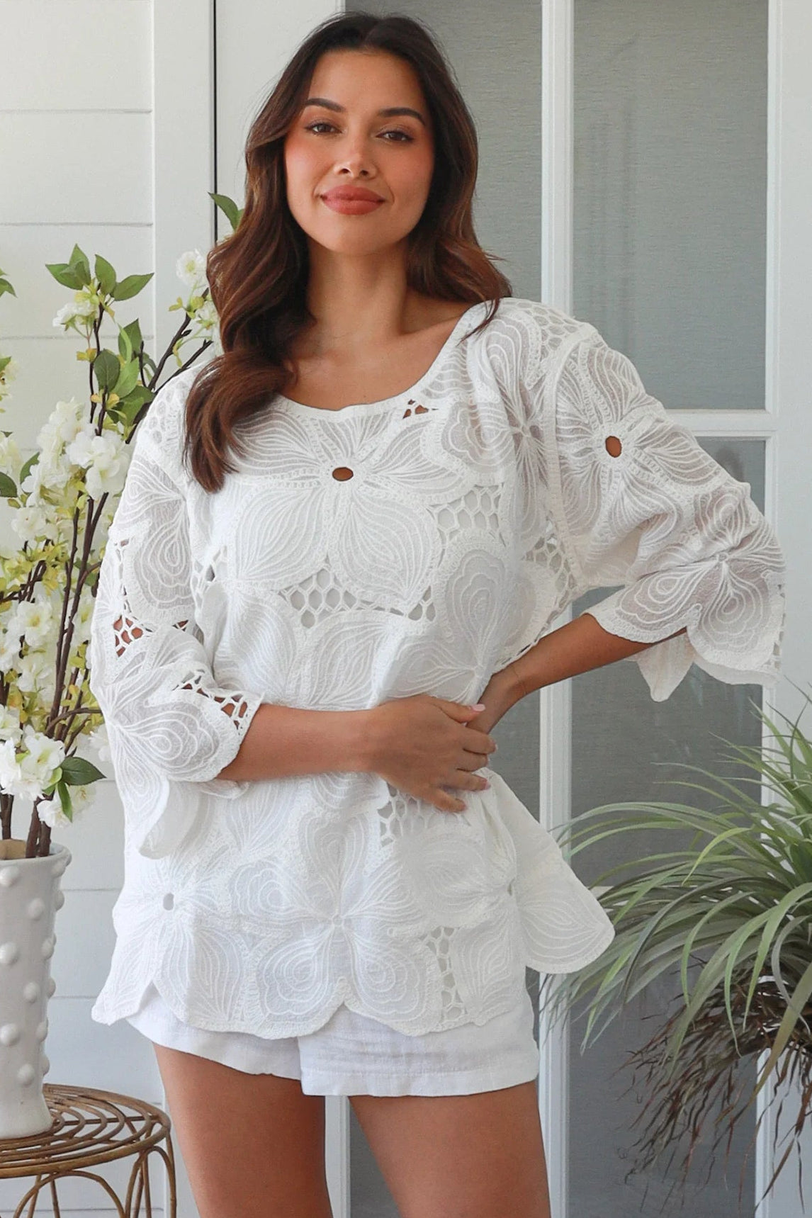 White embroidered cotton top with scalloped hem and three quarter sleeves styled for summer