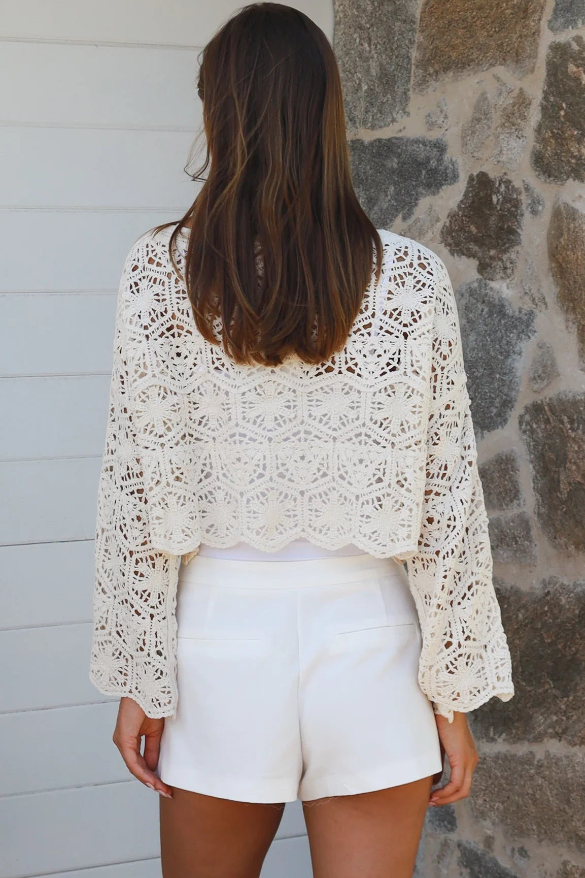 Cream crochet cotton long sleeve crop top with scalloped hem and flared cuffs styled with white shorts
