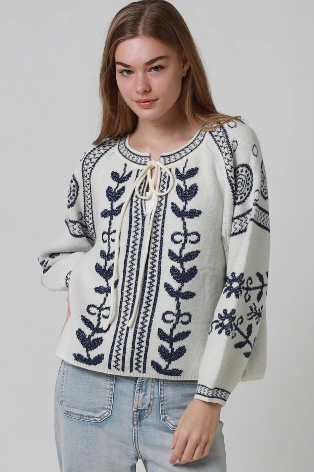 Woman wearing cream boho knit jumper with navy lurex detailing balloon sleeves textured winter styling and relaxed bohemian knitwear Australia