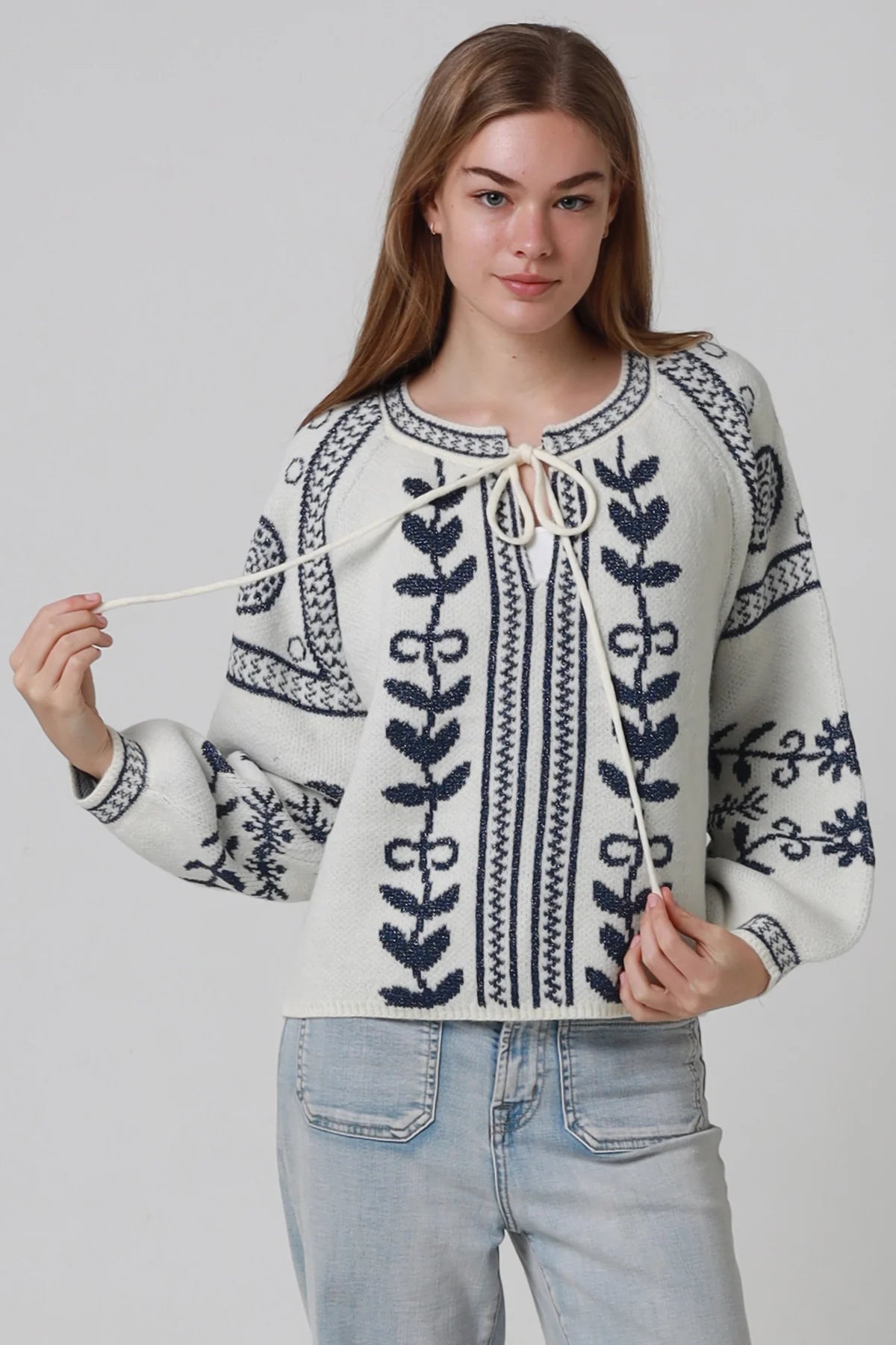 Woman wearing cream boho knit jumper with navy lurex detailing balloon sleeves textured winter styling and relaxed bohemian knitwear Australia