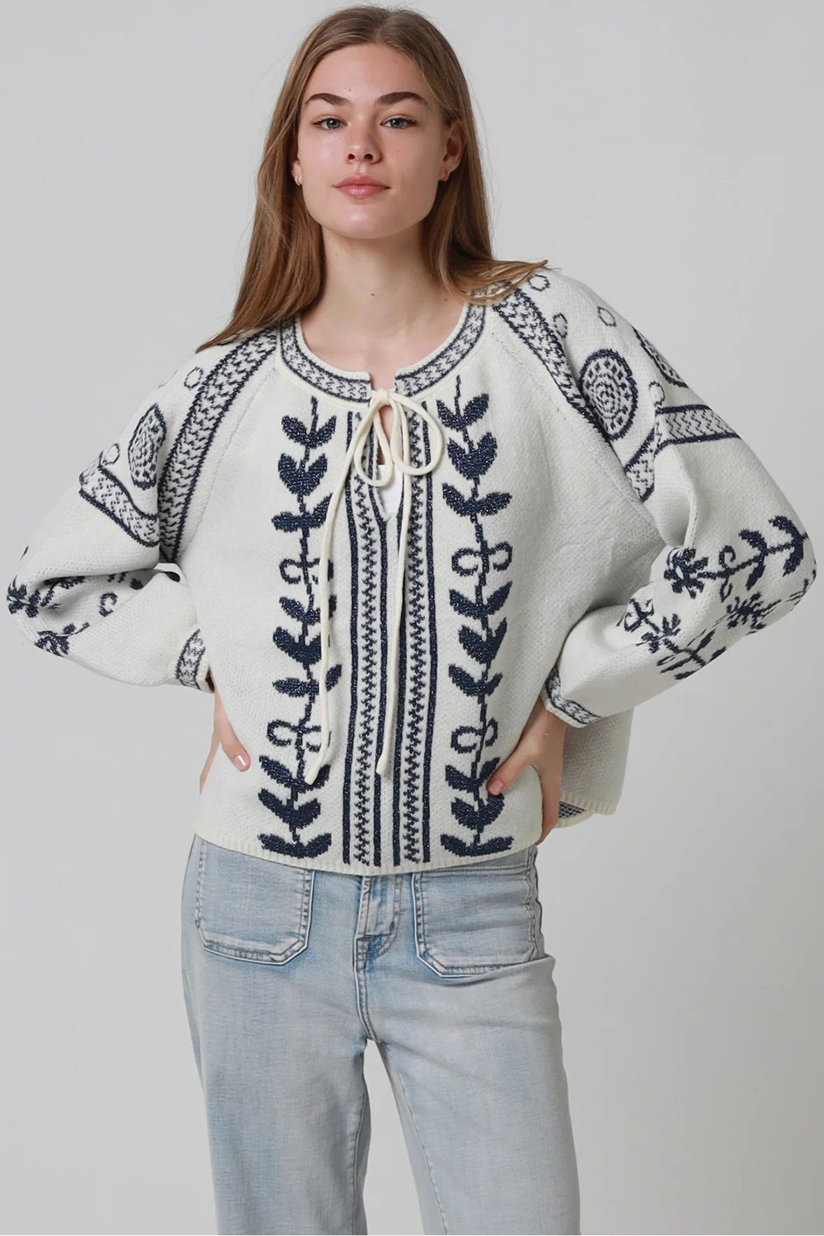 Woman wearing cream boho knit jumper with navy lurex detailing balloon sleeves textured winter styling and relaxed bohemian knitwear Australia