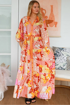 Jacqueline Floral Maxi Dress by Salty Palm in coral pink patchwork floral print with sash, pockets and button-through front