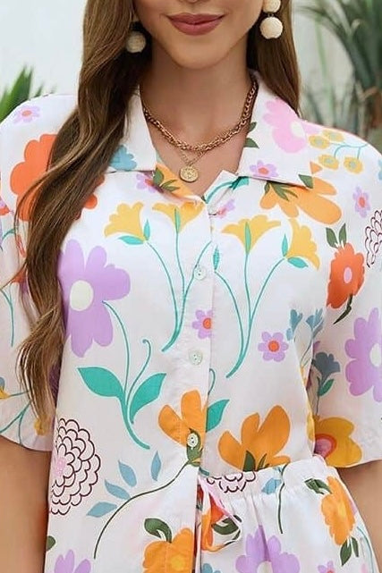 Woman wearing Mutig vintage floral shirt and short set with light base and colourful bohemian print styled for summer