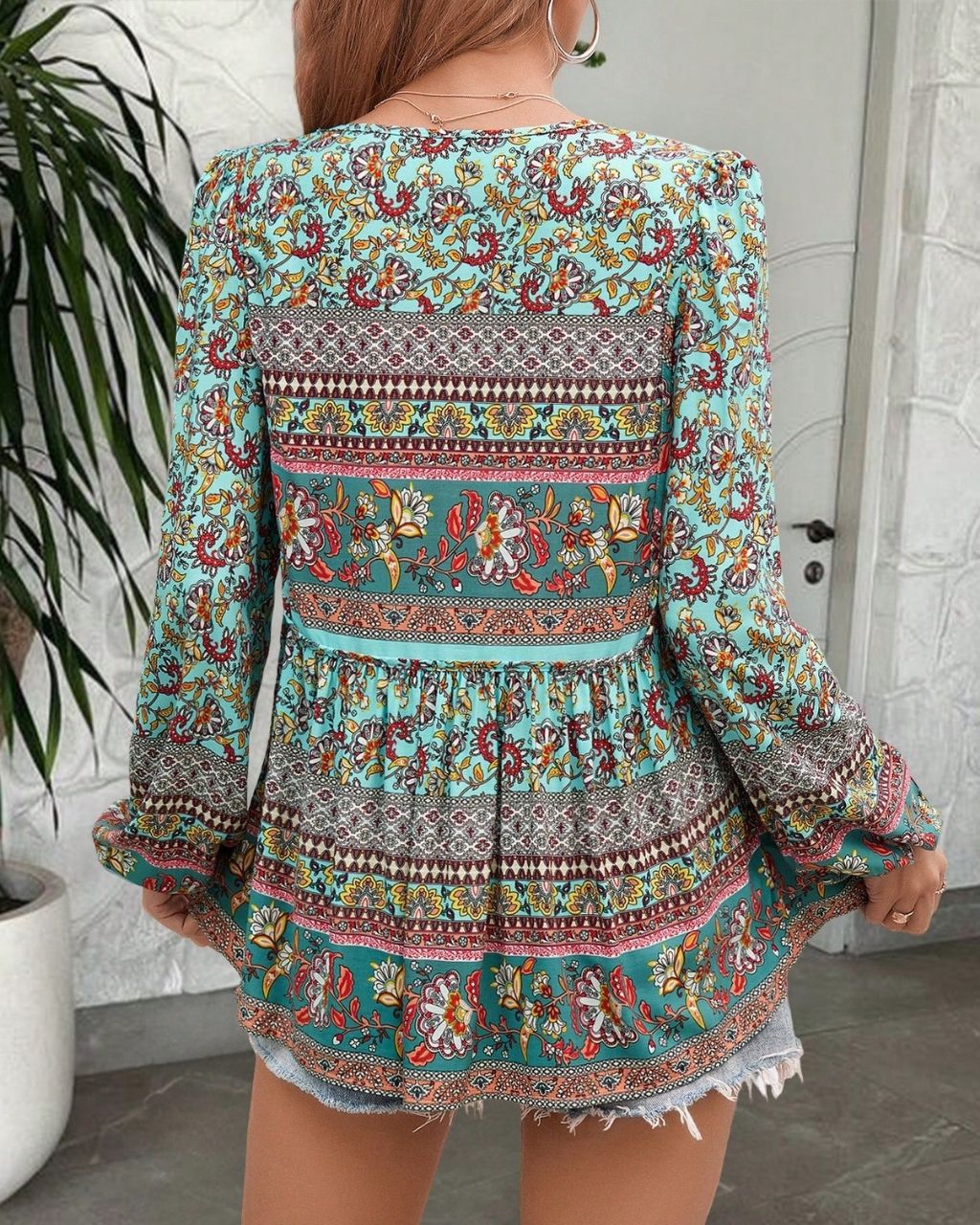 Woman in a vintage turquoise floral boho blouse with long peasant sleeves and tassel ties - The Jasmine Road Top Australia.
