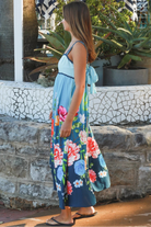 Woman wearing a teal floral boho maxi dress with tie-back detail, elasticated back and pockets – Australian bohemian fashion