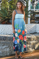 Woman wearing a teal floral boho maxi dress with tie-back detail, elasticated back and pockets – Australian bohemian fashion