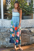 Woman wearing a teal floral boho maxi dress with tie-back detail, elasticated back and pockets – Australian bohemian fashion