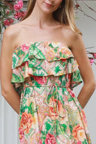 Model wearing a Dreamcatcher Raya strapless floral patchwork maxi dress in green and pink with ruffle bodice and tiered skirt