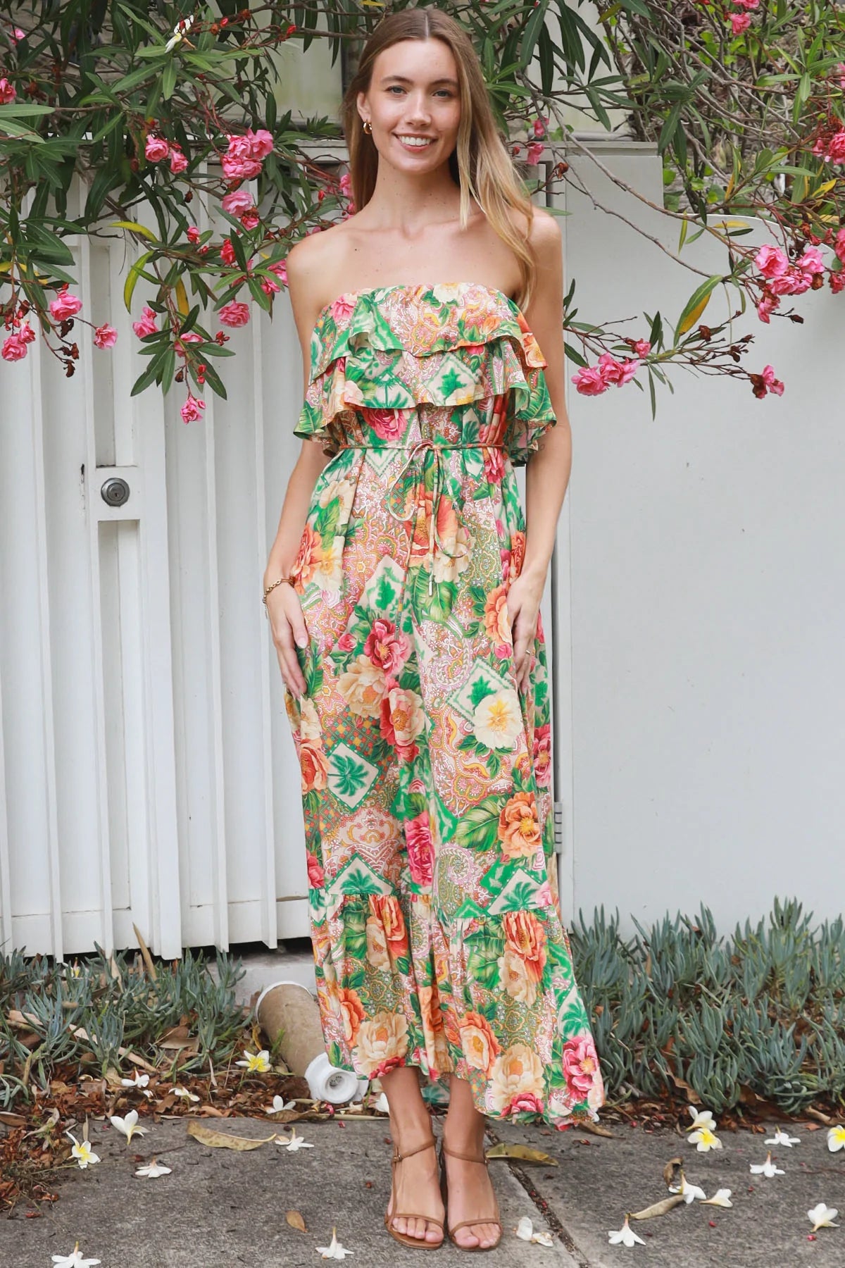 Model wearing a Dreamcatcher Raya strapless floral patchwork maxi dress in green and pink with ruffle bodice and tiered skirt