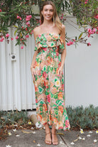 Model wearing a Dreamcatcher Raya strapless floral patchwork maxi dress in green and pink with ruffle bodice and tiered skirt