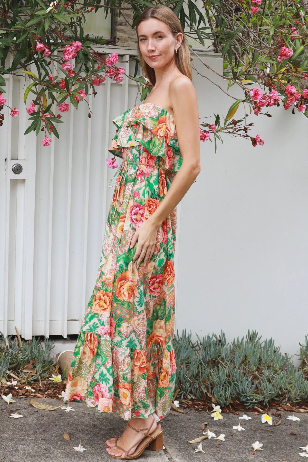 Model wearing a Dreamcatcher Raya strapless floral patchwork maxi dress in green and pink with ruffle bodice and tiered skirt