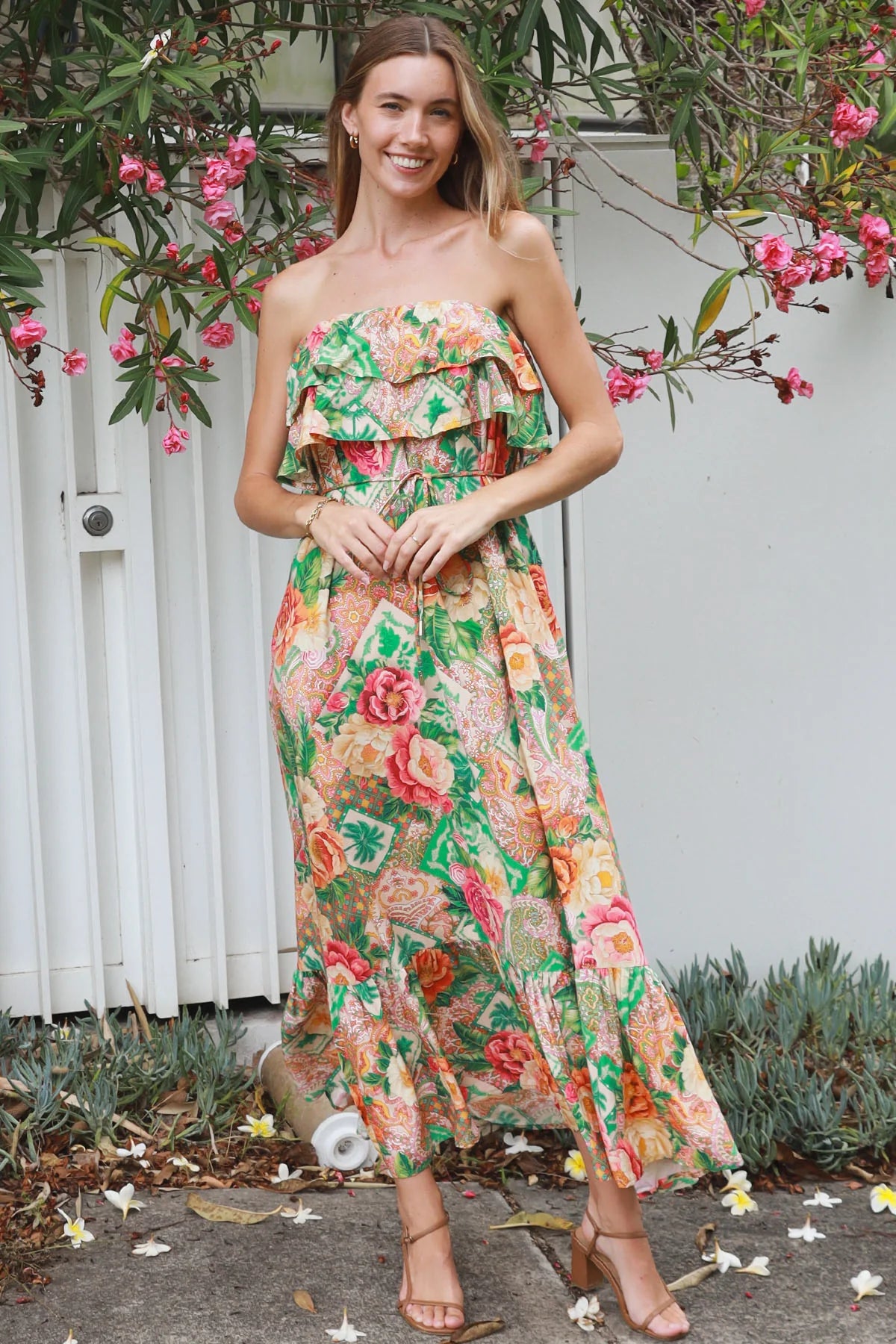 Model wearing a Dreamcatcher Raya strapless floral patchwork maxi dress in green and pink with ruffle bodice and tiered skirt