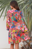 Woman wearing a jungle floral rayon above knee mini dress with blouson sleeves by Dreamcatcher in Australia