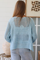 Woman wearing pastel blue crochet knit sweater styled with denim for a refined boho winter outfit Australia