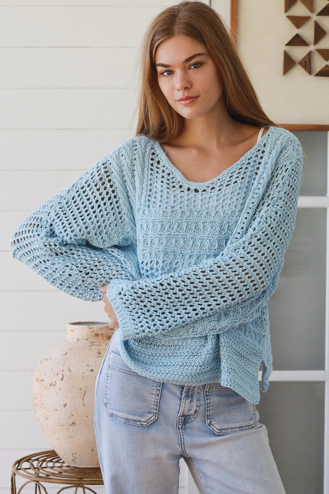 Woman wearing pastel blue crochet knit sweater styled with denim for a refined boho winter outfit Australia