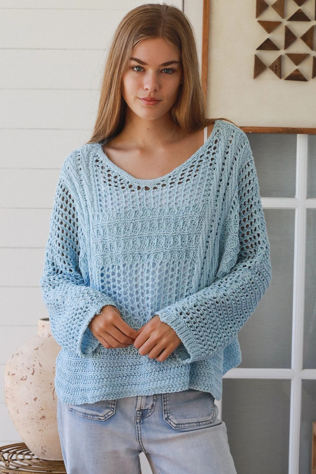 Woman wearing pastel blue crochet knit sweater styled with denim for a refined boho winter outfit Australia
