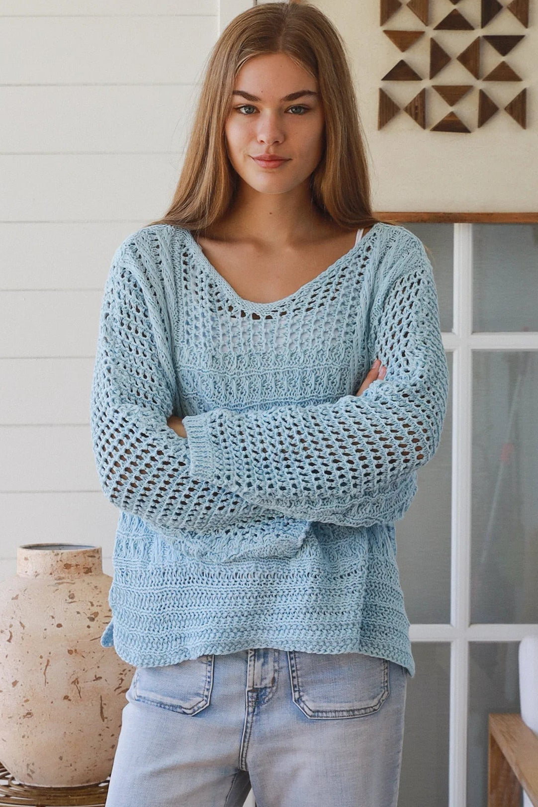 Woman wearing pastel blue crochet knit sweater styled with denim for a refined boho winter outfit Australia