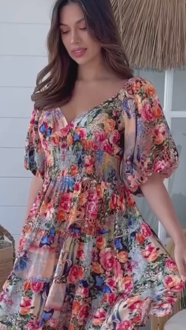 Woman twirling in the Hannah Mini Dress - a bohemian floral mini spinning gracefully in soft light