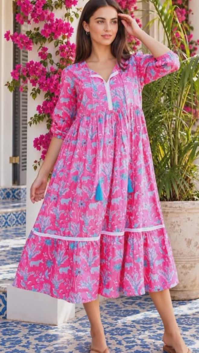 Model in motion wearing the Mahale Sanctuary Midi Dress Pluto Pink in 100% cotton with turquoise wildlife print, white lace trim and frill hem | Bohemian Love Runway