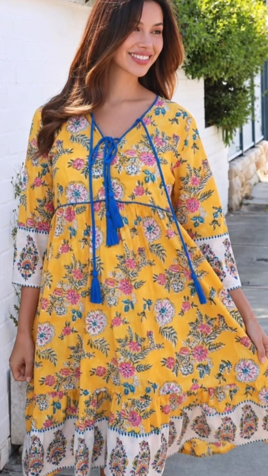 Model in motion wearing the Golden Dahlia Peacock Feather indian cotton boho dress with cobalt tassels and ornate floral border print at Bohemian Love Runway