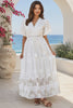 Model in motion wearing the Willow white embroidered cotton maxi dress with openwork lace and tassel ties by Salty Palm at Bohemian Love Runway